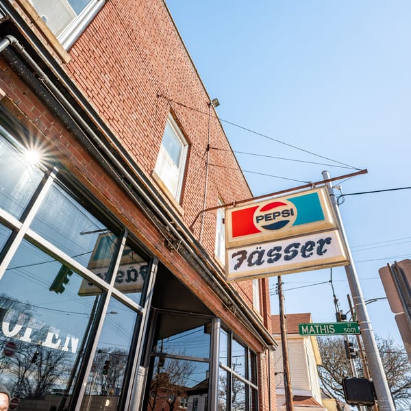 Exterior of Fässer bar-&-grill, a brick building with a Pepsi sign and large windows.