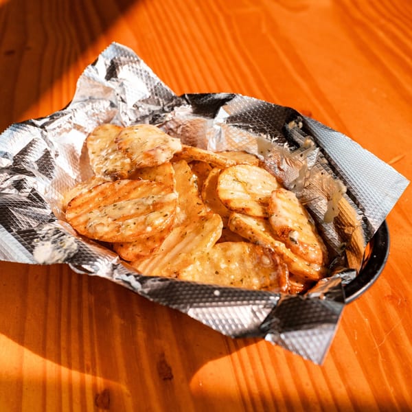 Fässer's crispy potato chips with seasoning and melted cheese in a foil-lined basket.